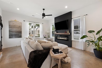 Living room featuring a glass covered fireplace, 