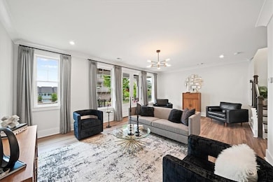 Living area with ornamental molding, a chandelier, stairway, wood finished floors, and recessed lighting