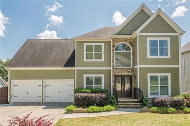 View of front facade featuring driveway, an attached garage, and french doors