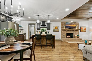 Dining area with a brick fireplace, a tray ceiling