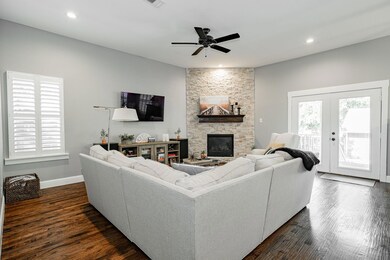 Living room with ceiling fan, french doors, a fire