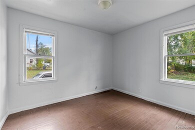 Unfurnished room with hardwood / wood-style floors and healthy amount of natural light