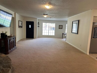 Carpeted foyer with wood walls and a textured ceil