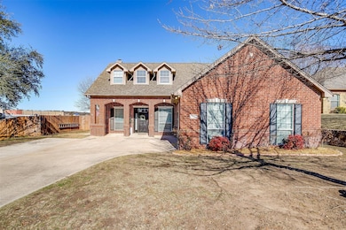 Cape cod-style house with covered porch, brick siding, roof with shingles, and a chimney