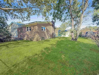 View of property exterior with brick siding and a chimney