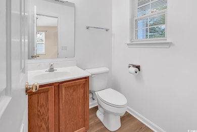Bathroom with toilet, wood finished floors, vanity