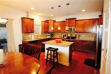 Large kitchen w/ castled cabinets, SS appliances, island with breakfast bar, and granite counter tops.