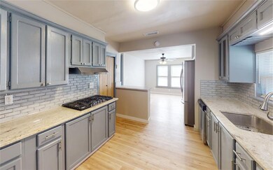 Kitchen with ceiling fan, sink, light wood-type fl