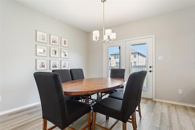 Dining area with light wood-style floors and a chandelier