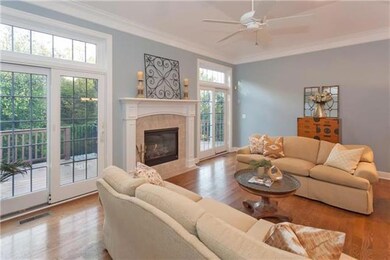 Doors open to composite deck and woods beyond the 