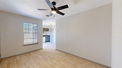 Spare room with visible vents, light wood-style floors, a sink, ceiling fan, and baseboards