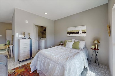 Bedroom featuring separate washer and dryer, baseb