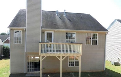 Rear view of property featuring a chimney and roof with shingles