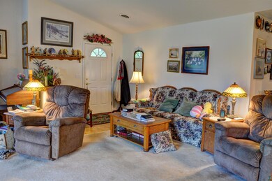 Living room with carpet flooring and lofted ceilin