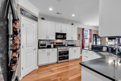 Kitchen featuring white cabinets, double oven range, crown molding, and sink
