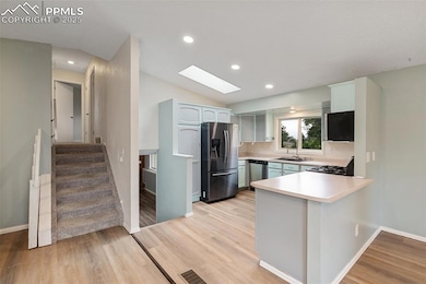 Open concept main level Kitchen, Dining room, and Living room light wood-style floors, and vaulted ceiling
