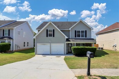 View of property featuring a garage, a front yard,