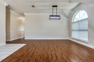 Unfurnished dining area featuring baseboards, wood finished floors, visible vents, and crown molding