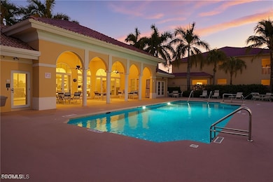 Pool at dusk featuring a patio, french doors, and a community pool. virtual sunset