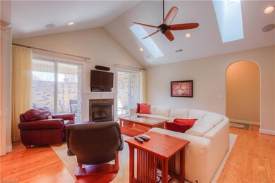 Spacious Great room with cathedral ceilings, skylights, ceiling fan, hardwood floors and an arched doorway to the Master Suite.