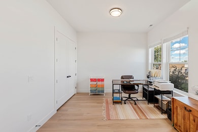 Home office with light wood-style flooring and baseboards