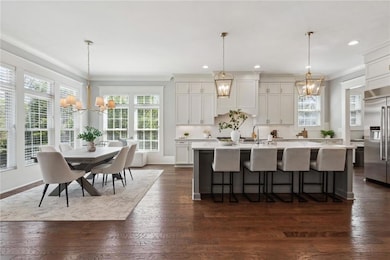 Dining room with coffered ceiling, a chandelier, visible vents, a decorative wall, and wood finished floors