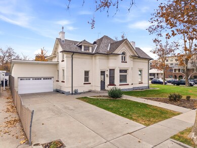 French country style house with a chimney, brick siding, a front yard, and concrete driveway