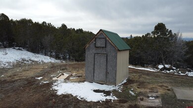 Snow covered structure with an outbuilding and a s