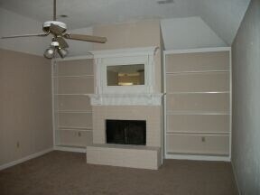 There is a fireplace and built-in bookshelves in t