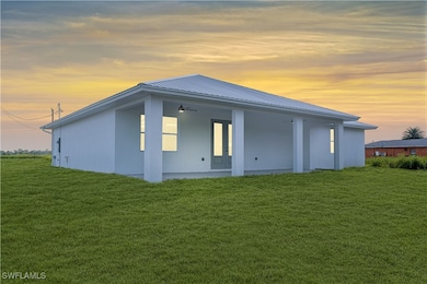 Back house at dusk featuring a yard