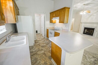 Bright kitchen with new flooring, wood cabinets.