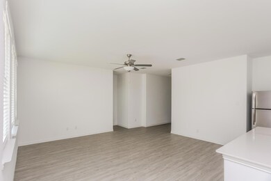 Unfurnished living room featuring ceiling fan and light wood-type flooring