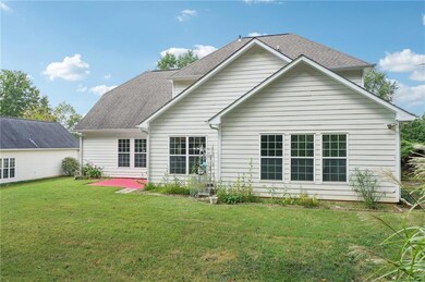 Back of house featuring a lawn, roof with shingles, and a patio area