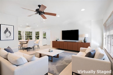 Living room featuring light wood-style floors, recessed lighting, natural light, large windows and ceiling fan