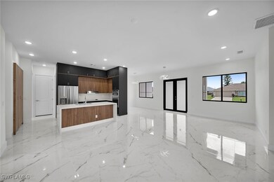 Kitchen with sink, a kitchen island, light tile patterned floors, and stainless steel refrigerator with ice dispenser