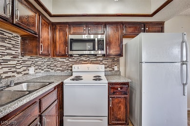 Kitchen with white appliances, decorative backsplash and granite countertops
