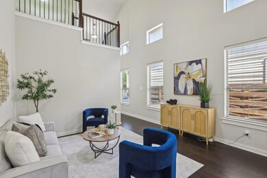 Living area featuring a towering ceiling, baseboa