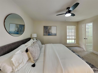 Carpeted bedroom with ceiling fan, baseboards, and