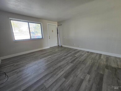 Empty room featuring dark wood-type flooring and baseboards