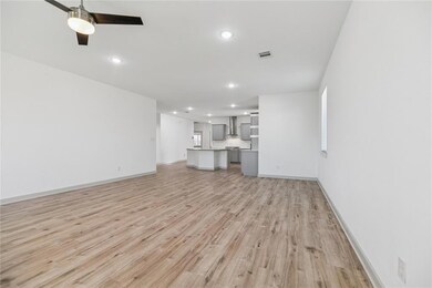 Spacious living room with recessed lighting & wide-planked flooring