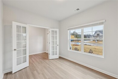 Spare room featuring french doors, wood finished f
