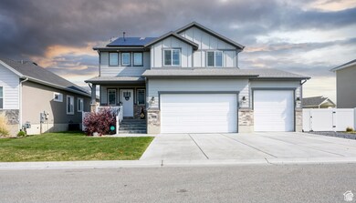 Craftsman house featuring covered porch, roof mounted solar panels, driveway, a garage, and a gate