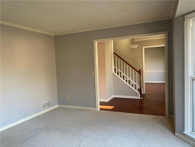 Carpeted empty room featuring ornamental molding a