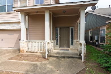 Doorway to property featuring stone siding, a gar