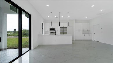 Unfurnished living room featuring a sink, recessed