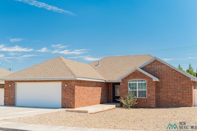 Ranch-style house featuring driveway, an attached garage, roof with shingles, and brick siding