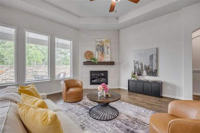 Living area featuring a ceiling fan, wood finishe