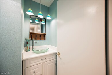 Bathroom featuring a textured wall and vanity