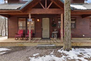 Snow covered property entrance with covered porch