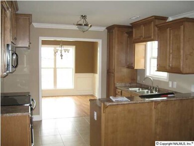 LARGE KITCHEN WITH CUSTOM CABINETS, CROWN MOLDING, STAINLESS APPLIANCES, TILE FLOORING AND MUCH MORE!